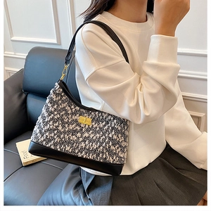Detalle de bolso de hombro retro en tweed con cierre dorado y ribetes de cuero negro