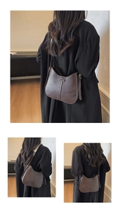 Detail of dark brown leather saddle bag with embossed lettering and adjustable strap