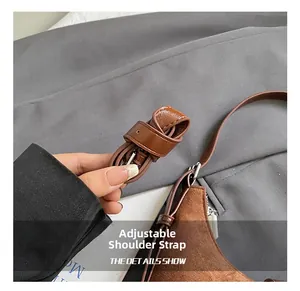 Λεπτομέρεια ρυθμιζόμενου δερμάτινου ιμάντα ώμου με ασημένια αγκράφα σε καφέ σουέτ τσάντα