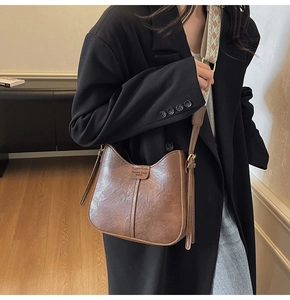 Detail of vintage brown leather hobo bag with ethnic style jacquard wide strap