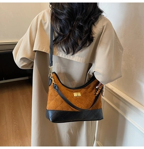 Detail of vintage quilted crossbody bag with golden turn-lock and wooden bead charm