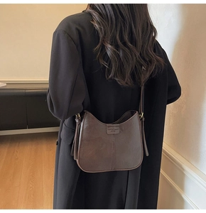Detailed view of the dark brown leather Hobo bucket bag with vintage logo on a model