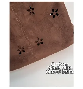 Detail of laser-cut floral pattern on dark brown faux suede with double-stitched edges