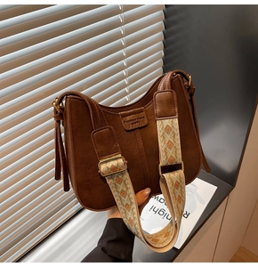 Detailed view of brown PU leather bucket bag with wide jacquard geometric shoulder strap
