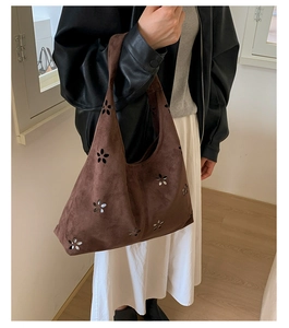Close-up of deep brown suede tote bag with intricate laser-cut hollow floral patterns