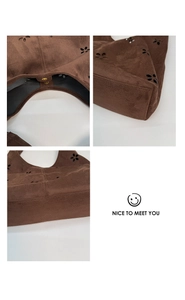 Detail view showing hollow flower pattern and magnetic snap on brown suede tote bag