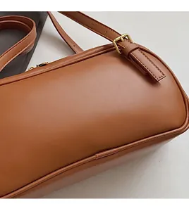 Détail de la texture en cuir marron doux avec boucle dorée et coutures précises