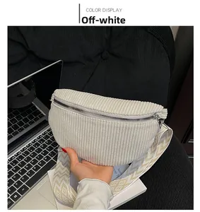 Detail of beige corduroy waist bag with geometric patterned strap and metal zipper