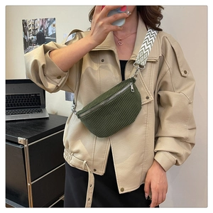 Detail of green corduroy waist bag with geometric woven strap on beige leather jacket