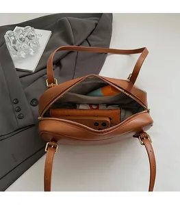 Vue intérieure du sac en cuir marron montrant l'espace pour téléphone et portefeuille