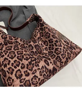Close-up detail of leopard print tote bag showing soft suede texture and brown strap