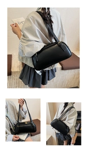 Vue détaillée de la texture du cuir synthétique noir et de la boucle de ce sac baguette
