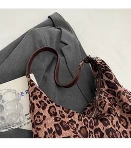 Detail showing the comfortable brown faux leather shoulder strap and secure zipper closure