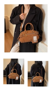 Detail view of brown leather Boston bag with vintage straps and adjustable metal buckles