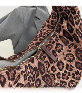 Close-up of leopard print tote featuring smooth metal zipper and herringbone lining
