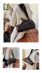 Détail du sac Boston en cuir marron foncé avec bandoulière réglable et boucles dorées