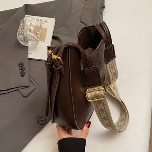Brown leather bucket bag with retro patterned wide strap and gold hardware accents