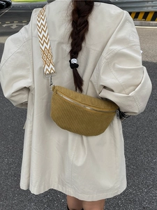 Mustard yellow corduroy crossbody bag with patterned jacquard strap shown on model