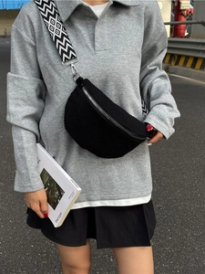 Street style black corduroy chest bag with geometric woven strap on model outdoors