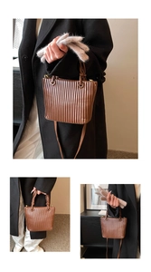 Detailed view of caramel brown pleated bucket bag with circular handles and leather texture