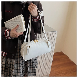 Vue détaillée d'un sac Boston cylindrique blanc avec fermeture éclair dorée et bandoulière