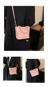 Detail of pink pleated bucket bag showing striped texture and woven handle