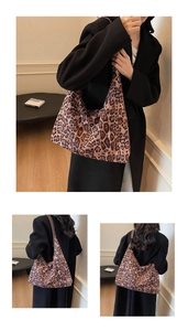 Detailed close-up showing the leopard print texture and brown leather strap of the tote bag