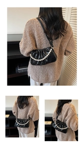 Détail du sac nuage plissé noir avec chaîne en perles et texture brillante élégante