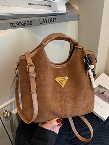 Borsa a secchiello in pelle scamosciata marrone con nappa di perline su scaffale