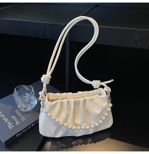 Détail du sac à bandoulière blanc plissé avec chaîne de perles et bandoulière à nœud
