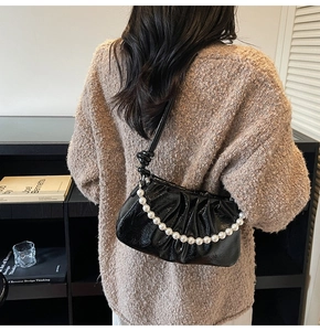 Détail du sac nuage froncé noir avec chaîne en perles et cuir verni brillant