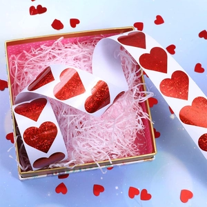 Macro shot of red holographic heart-shaped sticker roll in a luxury gift box packaging