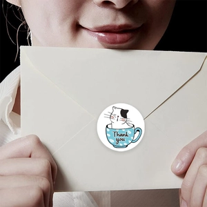 Autocollant Thank You avec chat mignon dans une tasse sur une enveloppe tenue par mains