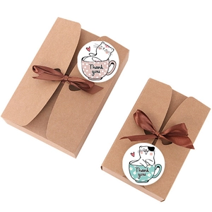 Détail de boîtes cadeaux en kraft brun avec rubans et autocollants de remerciement chat