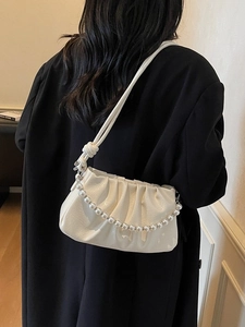 Sac nuage blanc plissé élégant avec chaîne en perles et bandoulière réglable porté par modèle
