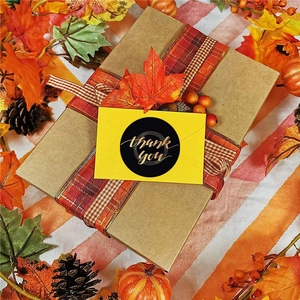 Black Thank You stickers with gold lettering on yellow envelopes for autumn gift wrapping