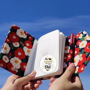 Coffret carnet en tissu floral chat avec pages quadrillées et stylo sur ciel bleu