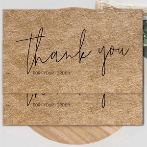 Brown kraft paper thank you for your order cards on a round wooden tray with dry branch