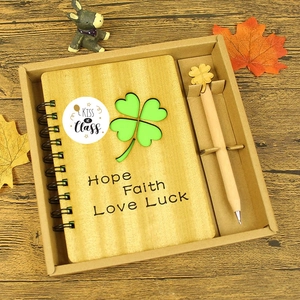 Coffret papeterie avec carnet en bois trèfle et stylo sur un bureau en bois