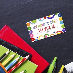 Child reward card with colorful patterns on a grey rock background with school stationery