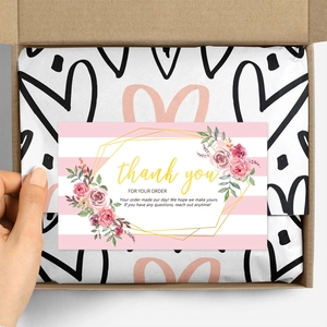 Detailed view of pink rose thank you card in kraft box with heart pattern packaging