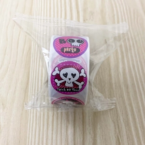 Roll of Halloween stickers with skull patterns and Trick or Treat text in purple packaging