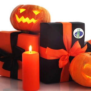 Halloween gift boxes with satin ribbons, Jack-o'-lanterns, and orange candle decor