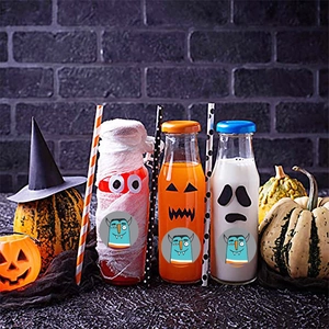 Set of Halloween themed decorative glass bottles with cartoon monster stickers and straws