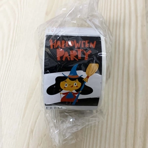 Close-up of Halloween sticker roll with wizard motifs and To-From labels on wood floor