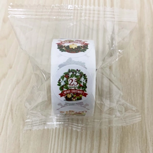 Detail of Christmas wreath stickers on a roll with red and green festive patterns