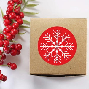 Christmas kraft paper gift box with red snowflake sticker and festive berry branch