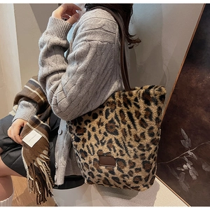 Detail of plush leopard print tote bag with brown handles and cozy autumn knitwear outfit