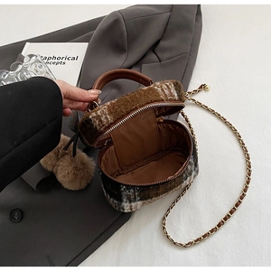 Detail van geruite wollen mini box-tas met kettingriem en zachte pluchen bedel