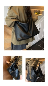 Detail of black large tote bag showing textured litchi grain and soft hobo structure